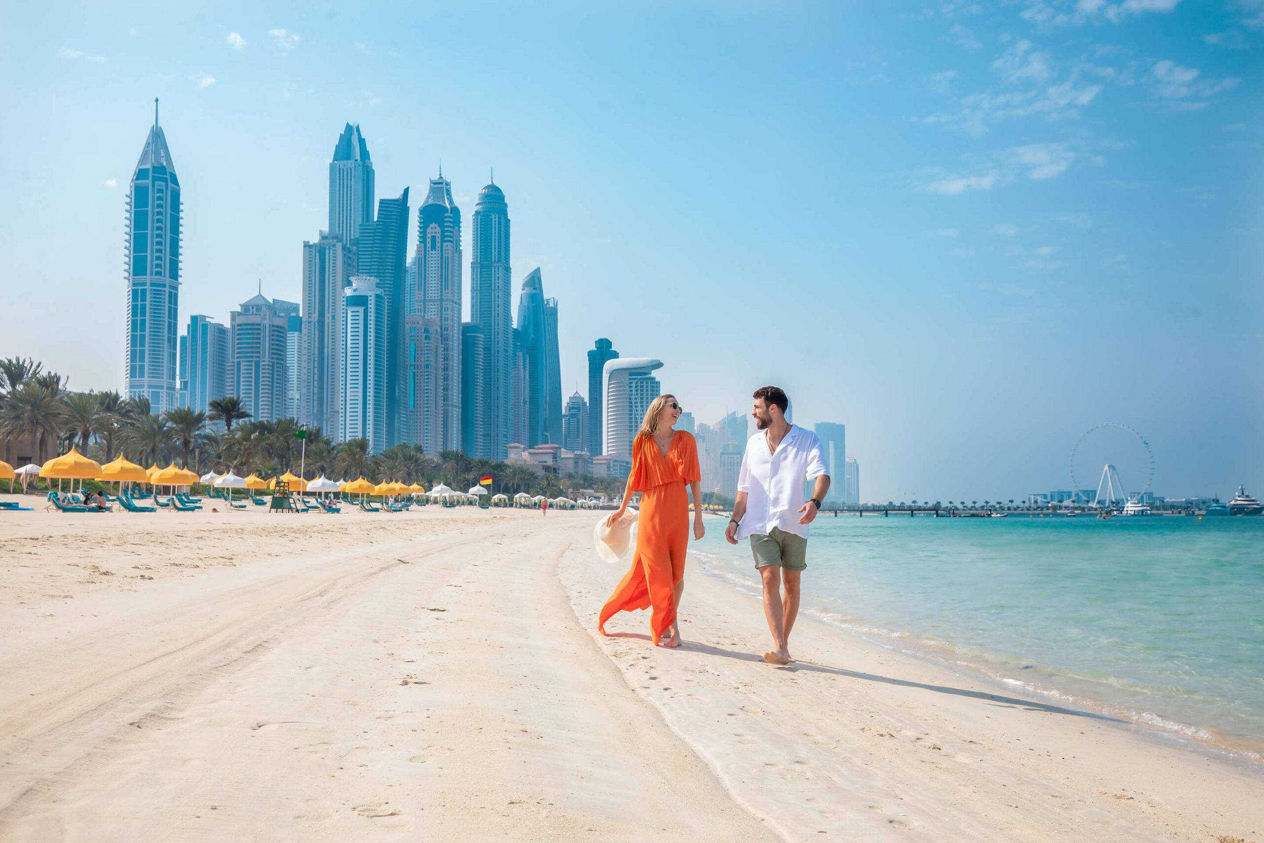 discover dubai couple on beach dubai skyline